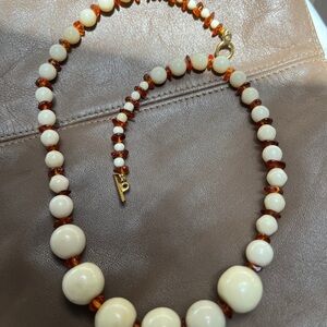 Artisan crafted ivory/cream colored glass beads and amber necklace .